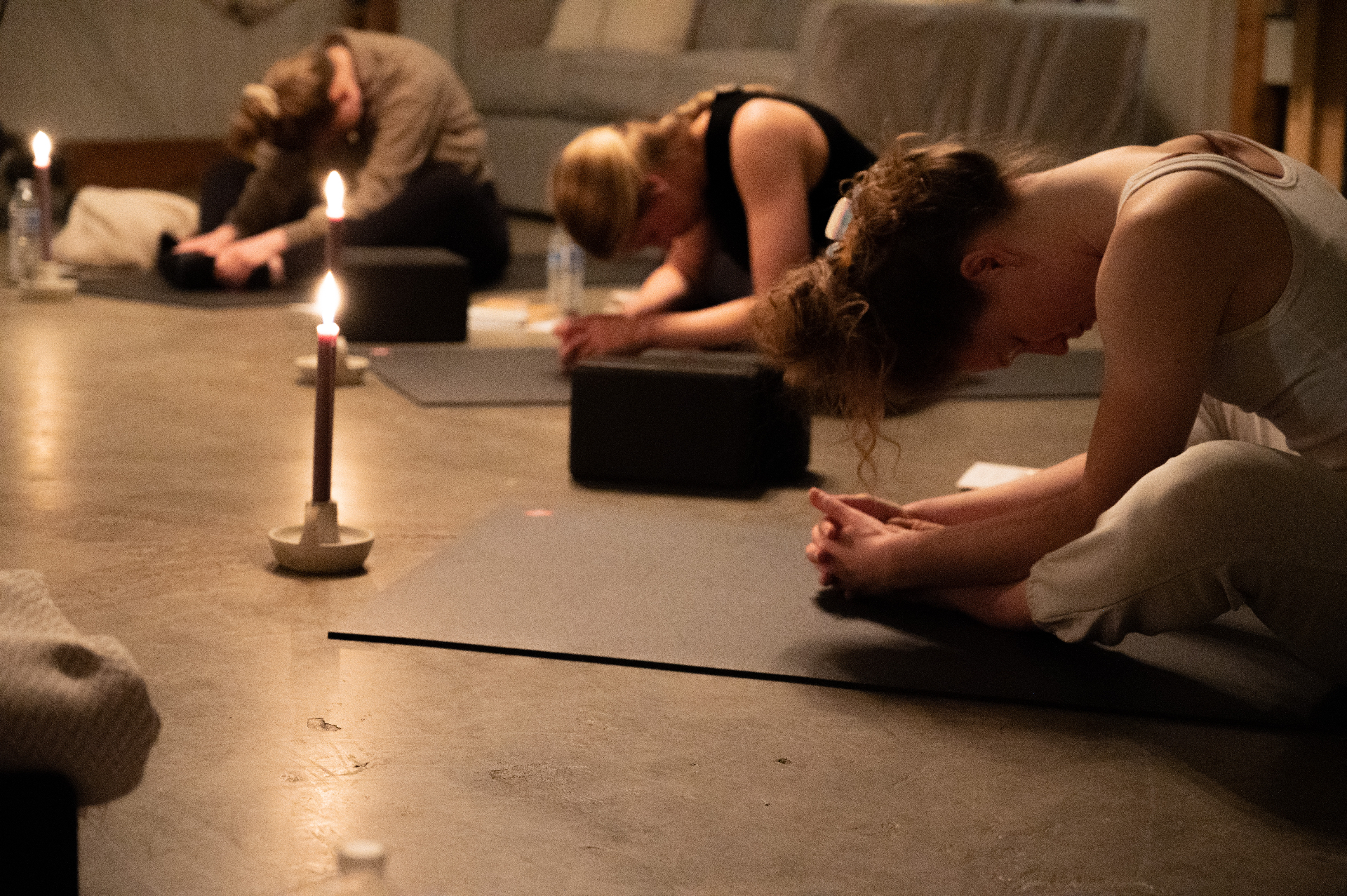 Women in candlelit yoga and prayer
